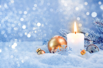 Fototapeta na wymiar Burning candle and snowy holiday decoration over frosty lights background