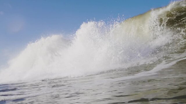 Cinematic underwater slow motion shot of a beautiful wave breaking on the coast of the Netherlands 4K