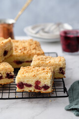 A stack of baked square pieces of cherry pie on a white background.