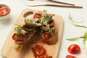bruschetta made from rye bread in Italian style, smoked meat and sun-dried tomatoes on bruschetta