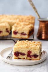 A stack of baked square pieces of cherry pie on a white background. Sour cream coffee cake with the cherry.