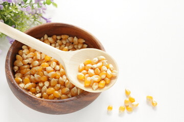 dried pop corn grain in wooden bowl with spoon for cooking ingredient