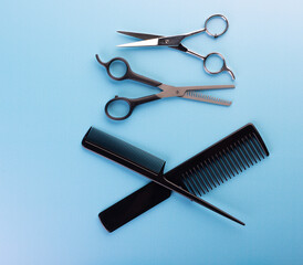 Professional tools for hairdresser isolated on blue background: hair combs and haircutting scissors