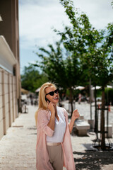 Fototapeta premium Beautiful businesswoman talking to the phone. Young woman outdoors...