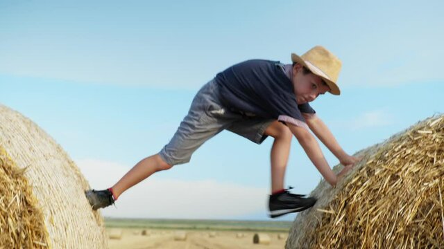 carefree childhood, young man having fun with male child throws boy up while playing with child on field with bales of hay, lifestyle