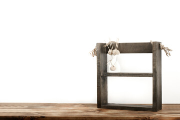 Vase of flowers on a wooden table. Brown frame shelf