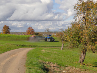 tractor throwing cow manure in a meadow in Germany