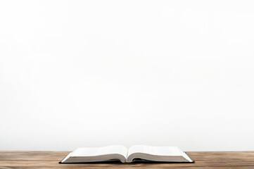 Open Bible book on a wooden table.