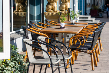 sidewalk open air cafe with empty chairs and  tables