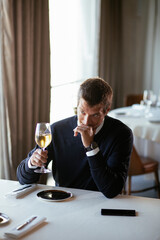 Handsome businessman drinking wine. Businessman enjoying in the restaurant
