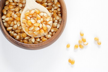 dried pop corn grain in wooden bowl with spoon for cooking ingredient