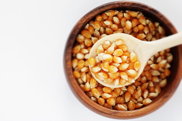dried pop corn grain in wooden bowl with spoon for cooking ingredient