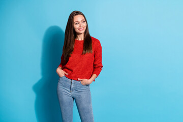 Photo of attractive girl look copyspace put hands pockets wear pullover isolated over blue color background