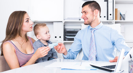 Portrait of manager of insurance company talking with female with child