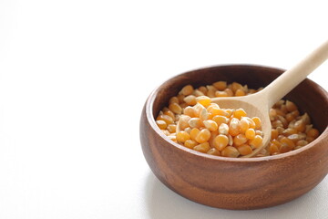 dried pop corn grain in wooden bowl with spoon for cooking ingredient