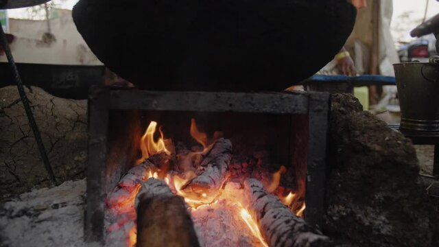 Traditional asian wok pan on a stone fire pit cinematic smooth slow motion shot 4K