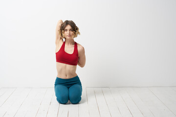 the girl is engaged in yoga on a light background Red T-shirt gesticulating with his hands