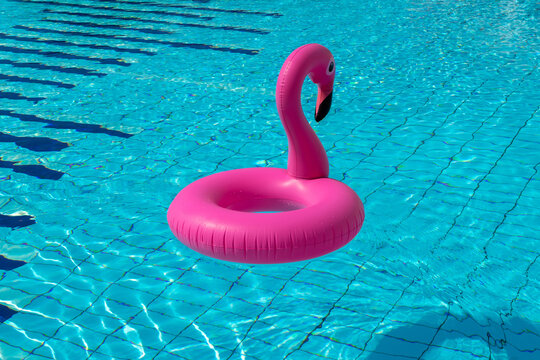 Sea background. Pink inflatable flamingo in pool water for summer beach background. Luxury lifestyle travel.