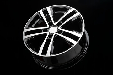 new shiny alloy wheel, color black with silver front. Dark background, side view