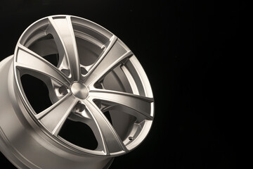 silver alloy wheel for crossovers and SUVs on a dark background, close-up. copy space for advertising and ad text