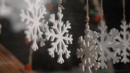 Christmas jewelry snowflake hanging on a thread behind the glass in the house