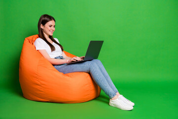 Profile photo of pretty young woman hold computer texting email freelancer dress white t-shirt jeans sneakers isolated on green background