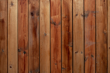 Naklejka premium old wooden fence made from gray brown red planks. vertical lines. rough surface texture
