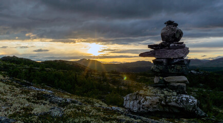 Cairn outdoors in nature during golden hour and sunset. Panoramic view. Travelling and landscapes concept.
