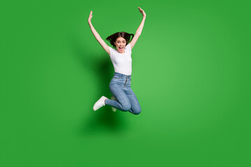 Full body photo of energetic girl jump raise arms wear casual style clothes isolated over green...