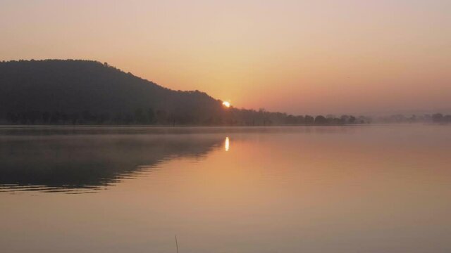 Epic cinematic colourful sunrise above a lake with beautiful reflection 4K