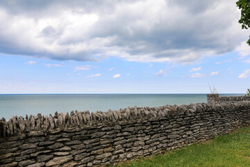 Stone wall at Krull Park overlooking Lake Ontario. Rain clouds over the lake in the spring at Olcott, New York.