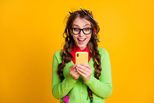 Photo of excited nerd girl read college exam news smartphone isolated yellow color background