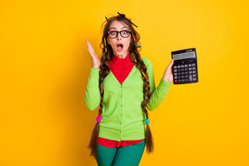 Photo of geek girl with messy hairdo hold calculator astonished isolated bright color background