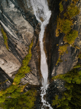 Aerial view of a majestic waterfall in Val di Mello, Lombardy, Italy.