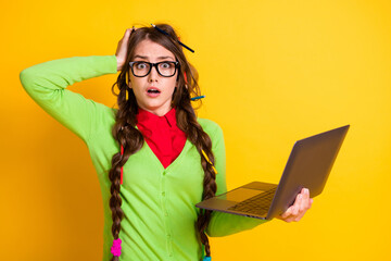 Portrait of attractive funky worried stunned girl holding in hands laptop learning isolated over...