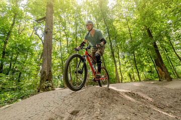 Man riding bicycle on forest road