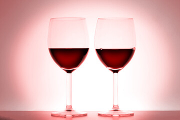 two wine glasses on red background with copy space for your text