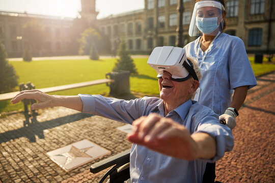 Smiling senior man using virtual reality device outdoors