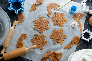 Christmas baking cookies snowflakes shape. Raw dough, cookie cutters, rolling pin. Abstract winter food background.