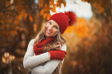 Portrait of smiling woman wearing woolen accessories. Young woman in beautiful autumn park, concept autumn