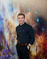 portrait of a handsome sports guy in a black shirt on a background of starry sky. Portraits with a...