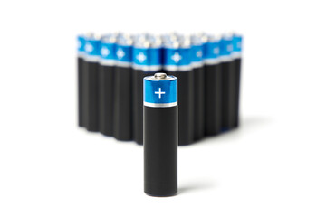 A closeup of a black battery with a blue border, against the background of other batteries.