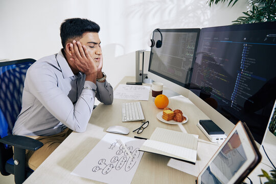 Tired Young Indian Programmer Almost Sleeping At His Desk After Working On Difficult Project All Day Long