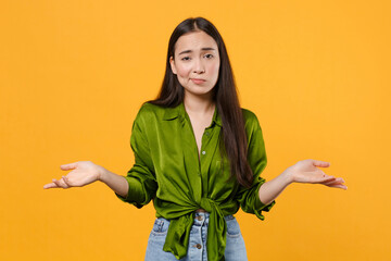 Confused puzzled upset displeased young brunette asian woman 20s wearing casual basic green shirt...