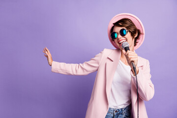 Photo of adorable pretty bob hair young lady wear cap coat glasses singing in mike isolated on...