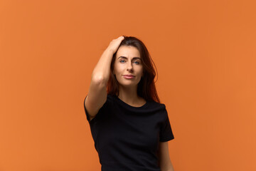 Confident charming playful coquettish caucasian woman in black t-shirt keeps hand on hair, smiling...