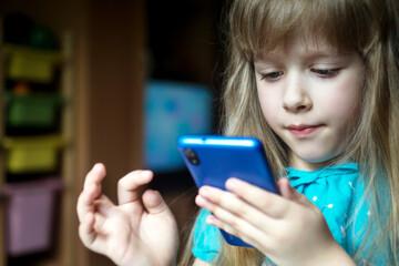 little blonde girl playing games on her phone