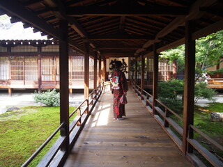 An Asian woman in a traditional Japanese kimono walking down the hallway, Zen garden, Kennin-ji Temple, Kyoto, Japan