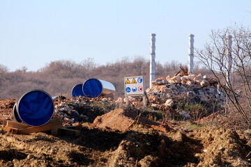 Oil pipeline construction site with large diameter pipes left over small hill for connecting and...