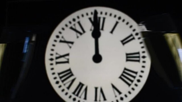 CELEBRATION OF THE NEW YEAR, glasses raising with champagne with the clock unfocussed
